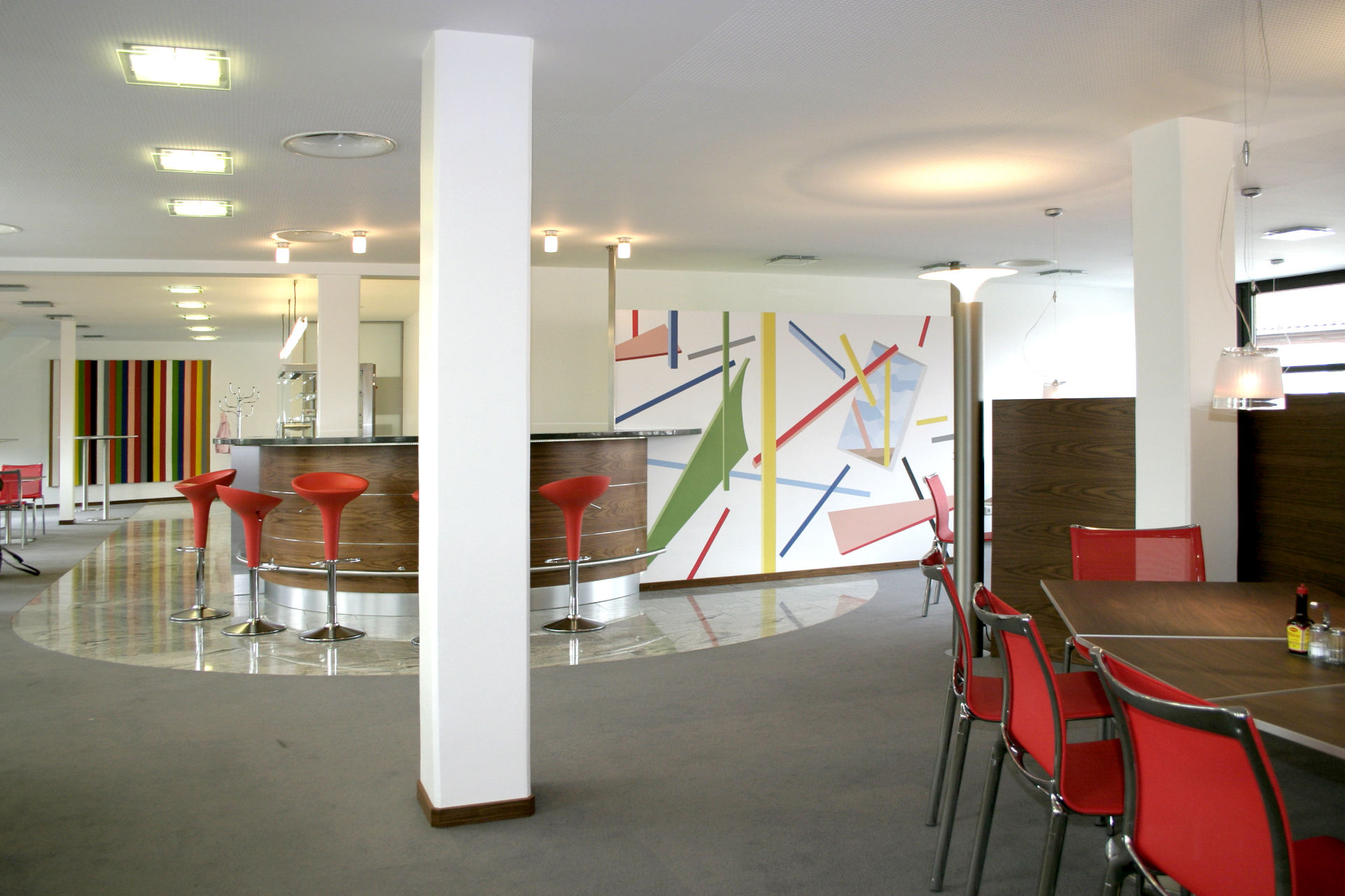 SPARKASSE CELLE. Eng verbunden mit einer ästhetischen und funktionalen Innenarchitektur des Raumes, spielt die konstruktivistische Wandmalerei von Uwe J. Fehrmann mit geometrischen Formen und der Fantasie der Besucher in den Räumen Sparkasse.