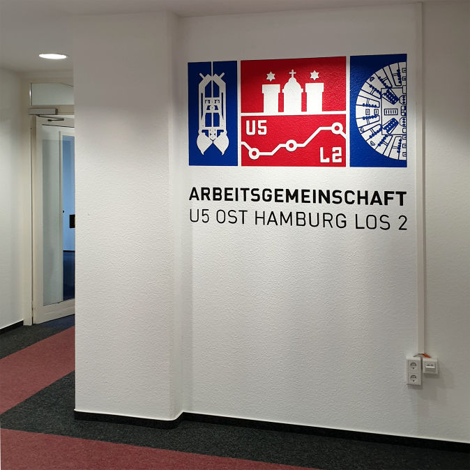Corporate Identity - das Logo Ihres Unternehmens handgemalt! Wandmalerei - Das gemalte Logo des Unternehmens im Flurbereich | Arbeitsgemeinschaft U5 Ost Hamburg Los 2